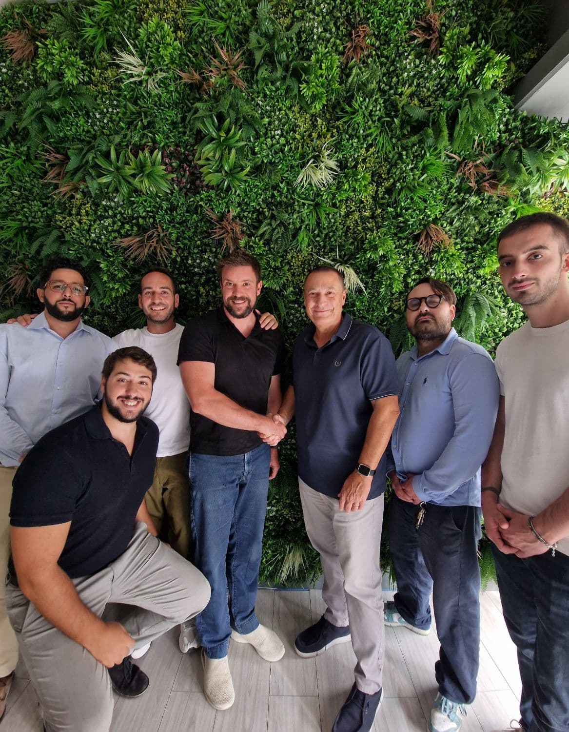 Il team di E-SME davanti a una parete verde